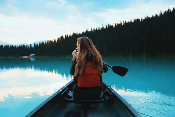 woman in canoe on blue water looking for mindfulness classes and coaching in seattle for adults and teens with anxiety depression stress trauma shame recovery