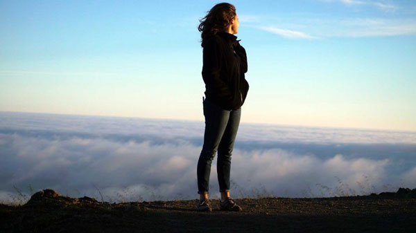 woman looking over clouds and horizon for mindfulness classes and coaching in seattle for adults and teens with anxiety depression stress trauma