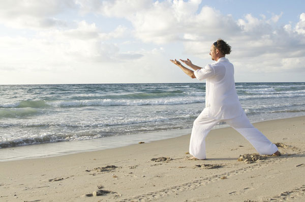 man on beach doing qi gong meditation classes and coaching in seattle for adults and teens with anxiety depression stress trauma